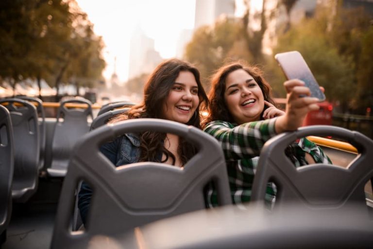 Two young women taking selfie on bus tour